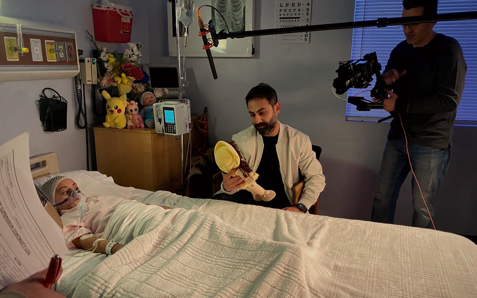Behind-the-scenes hospital set with performers, camera and boom microphone